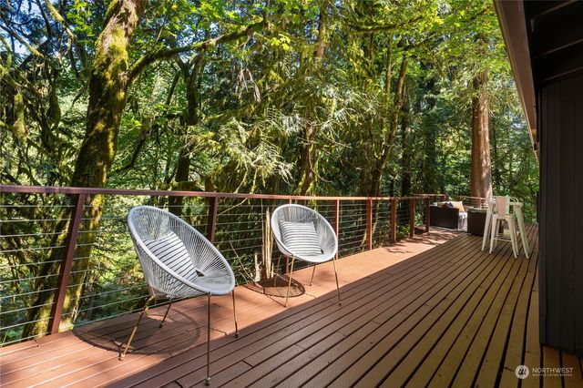 a balcony with wooden floor table and chairs