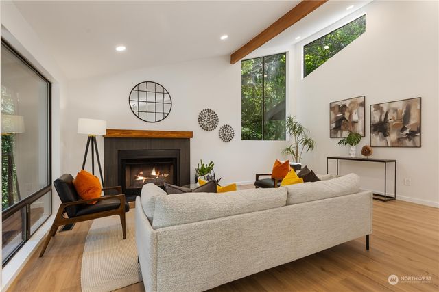 a living room with furniture a fireplace and a large window