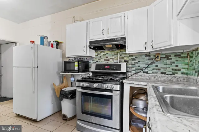 a kitchen with stainless steel appliances granite countertop a stove a refrigerator and a sink