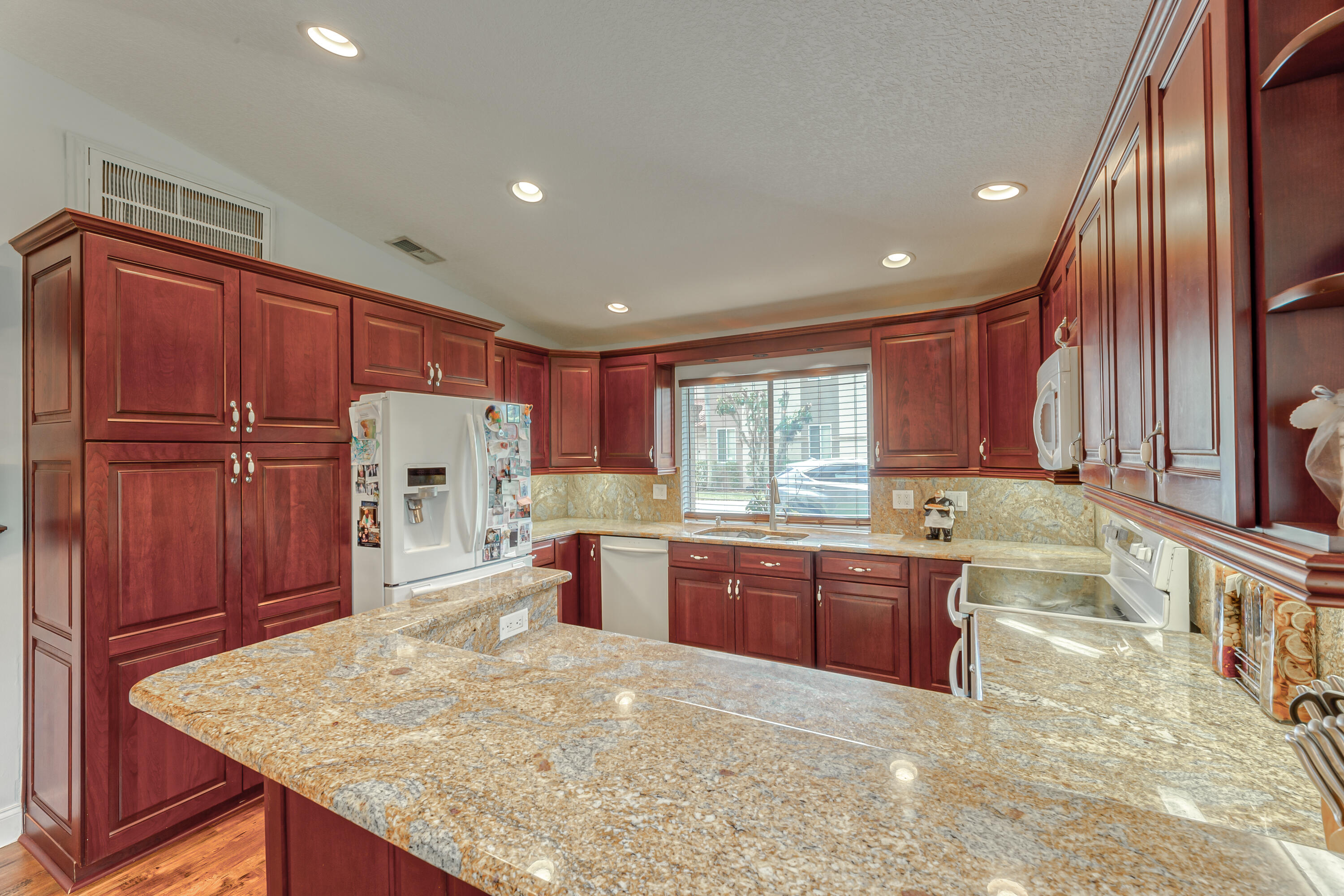 6816 Via Regina Boca Raton, FL 33433 - Photo 7 of 36 a large kitchen with kitchen island granite countertop wooden cabinets a sink and dishwasher