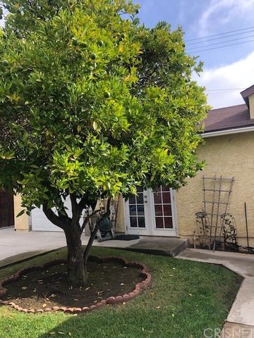 a tree in front of a white house