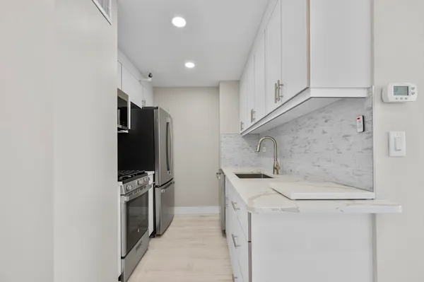 a kitchen with a sink cabinets and toilet