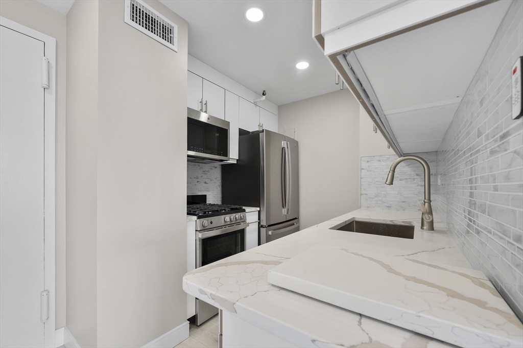 151 Tremont Street, Unit 18M Boston, MA 02111 - Photo 14 of 35 a bedroom with a bed and a television