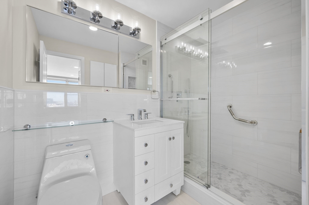 151 Tremont Street, Unit 18M Boston, MA 02111 - Photo 17 of 35 a bathroom with a shower sink and mirror
