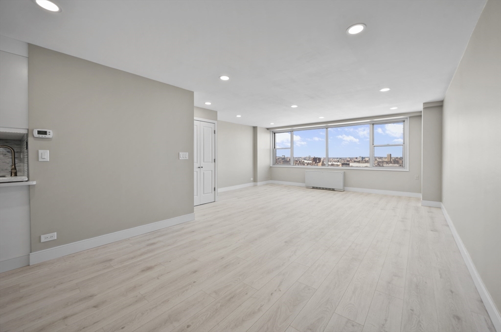 151 Tremont Street, Unit 18M Boston, MA 02111 - Photo 4 of 35 a view of an empty room with a window and kitchen view