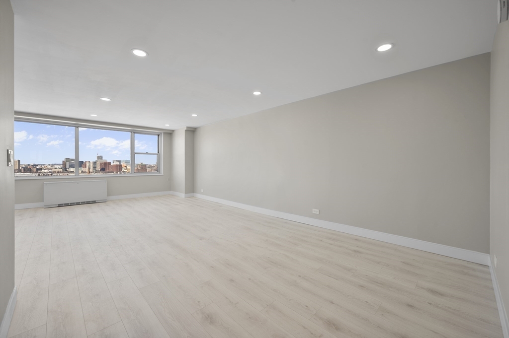 151 Tremont Street, Unit 18M Boston, MA 02111 - Photo 5 of 35 a view of an empty room with a kitchen