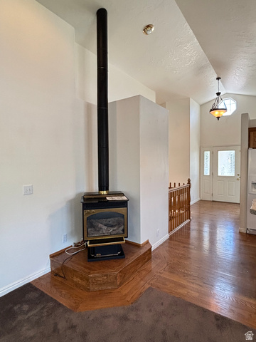 798 South 600 East Payson, UT 84651 - Photo 17 of 31 Corner fireplace with wood-finish hearth, dark wood-finish flooring, white walls, and a wood banister