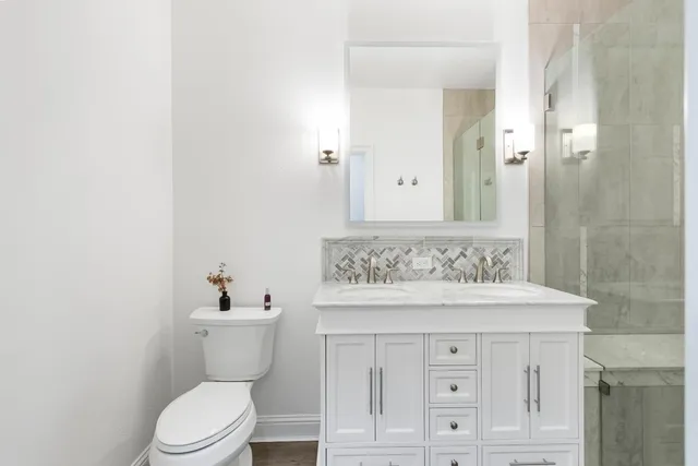 a bathroom with a sink a toilet and shower