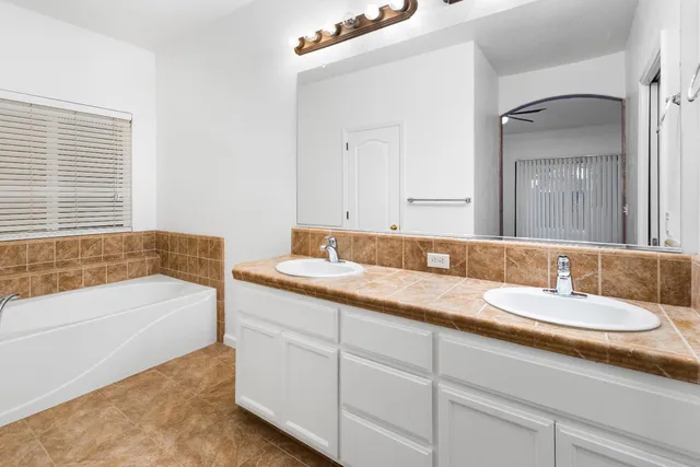 a bathroom with a tub sink and mirror