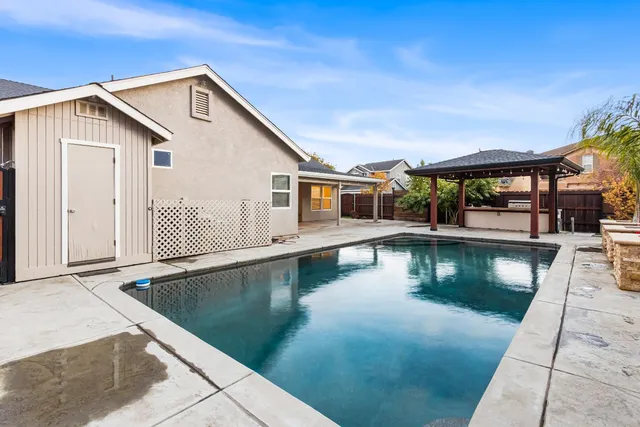 a view of a house with pool and sitting area