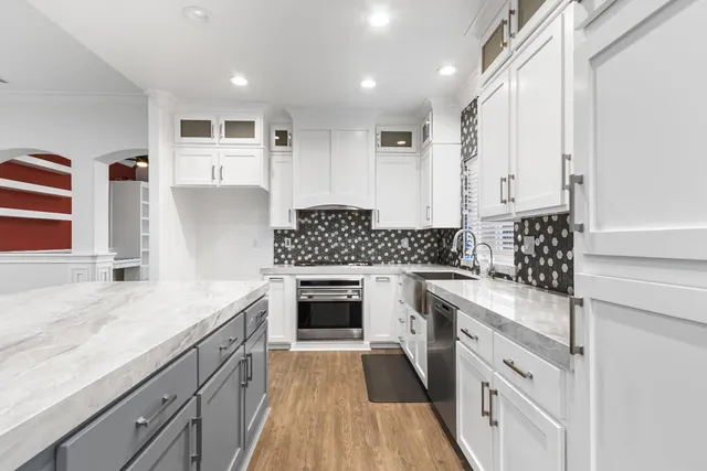a kitchen with granite countertop white cabinets and white appliances