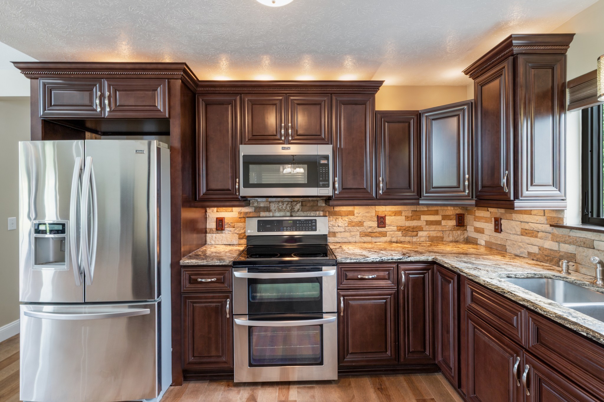 3791 Sylvia Road Dickson, TN 37055 - Photo 22 of 82 a kitchen with granite countertop a refrigerator stove and microwave