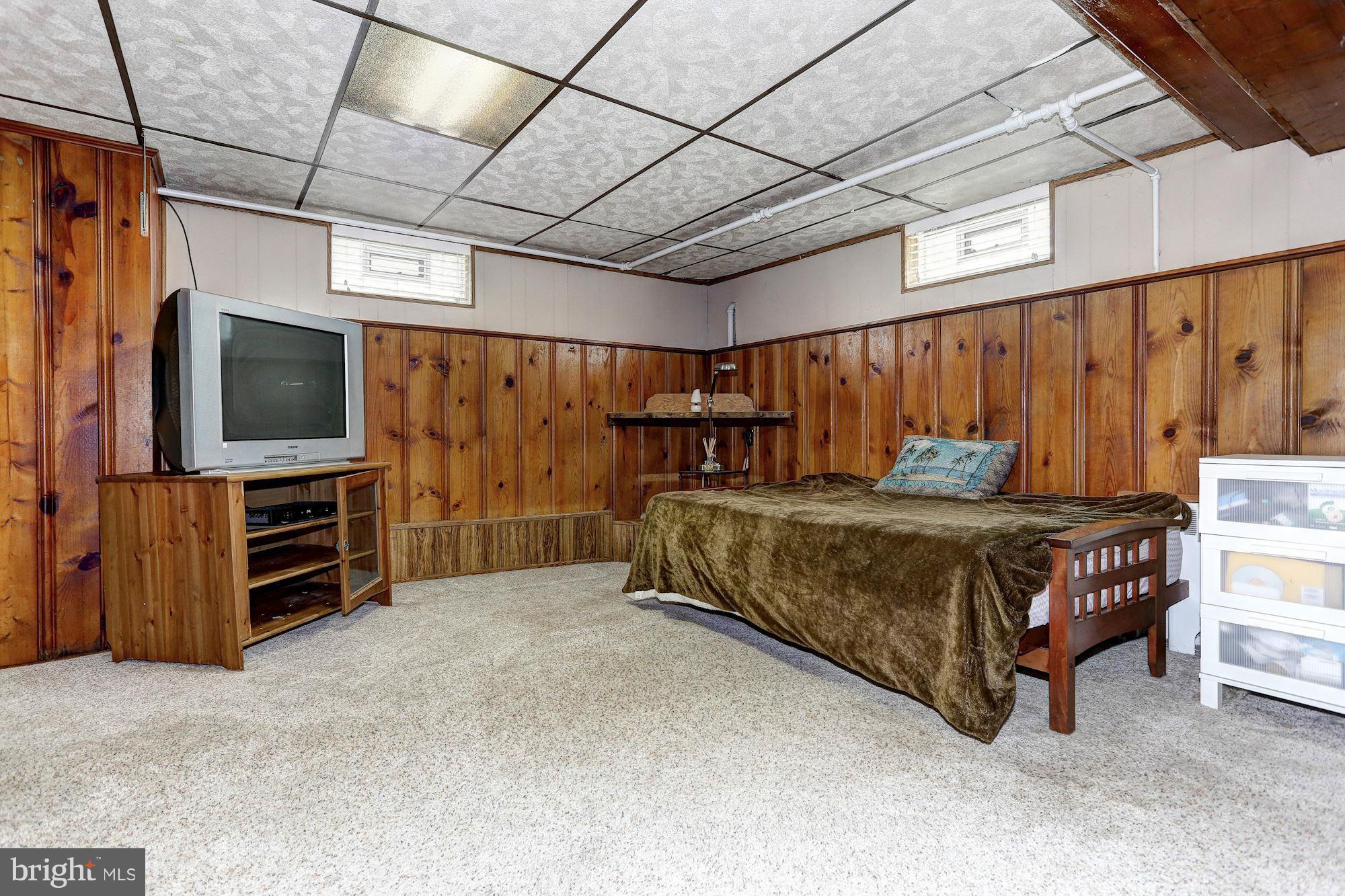 402 North Rolling Road Catonsville, MD 21228 - Photo 13 of 17 a bedroom with a bed and a flat tv screen on wall