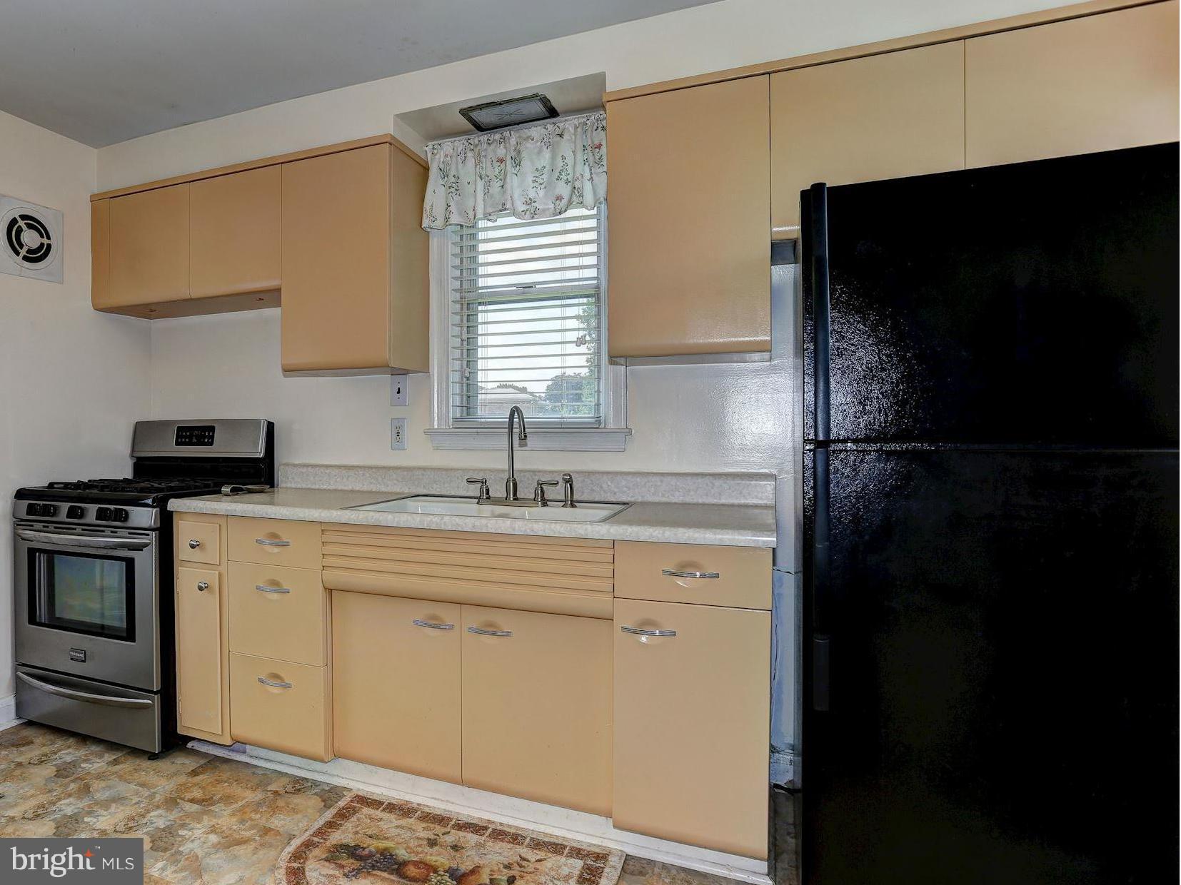 402 North Rolling Road Catonsville, MD 21228 - Photo 6 of 17 a kitchen with a sink and a stove top oven