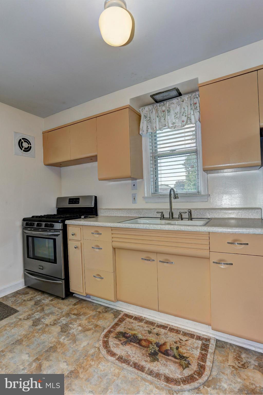 402 North Rolling Road Catonsville, MD 21228 - Photo 7 of 17 a kitchen with a stove a sink and a window