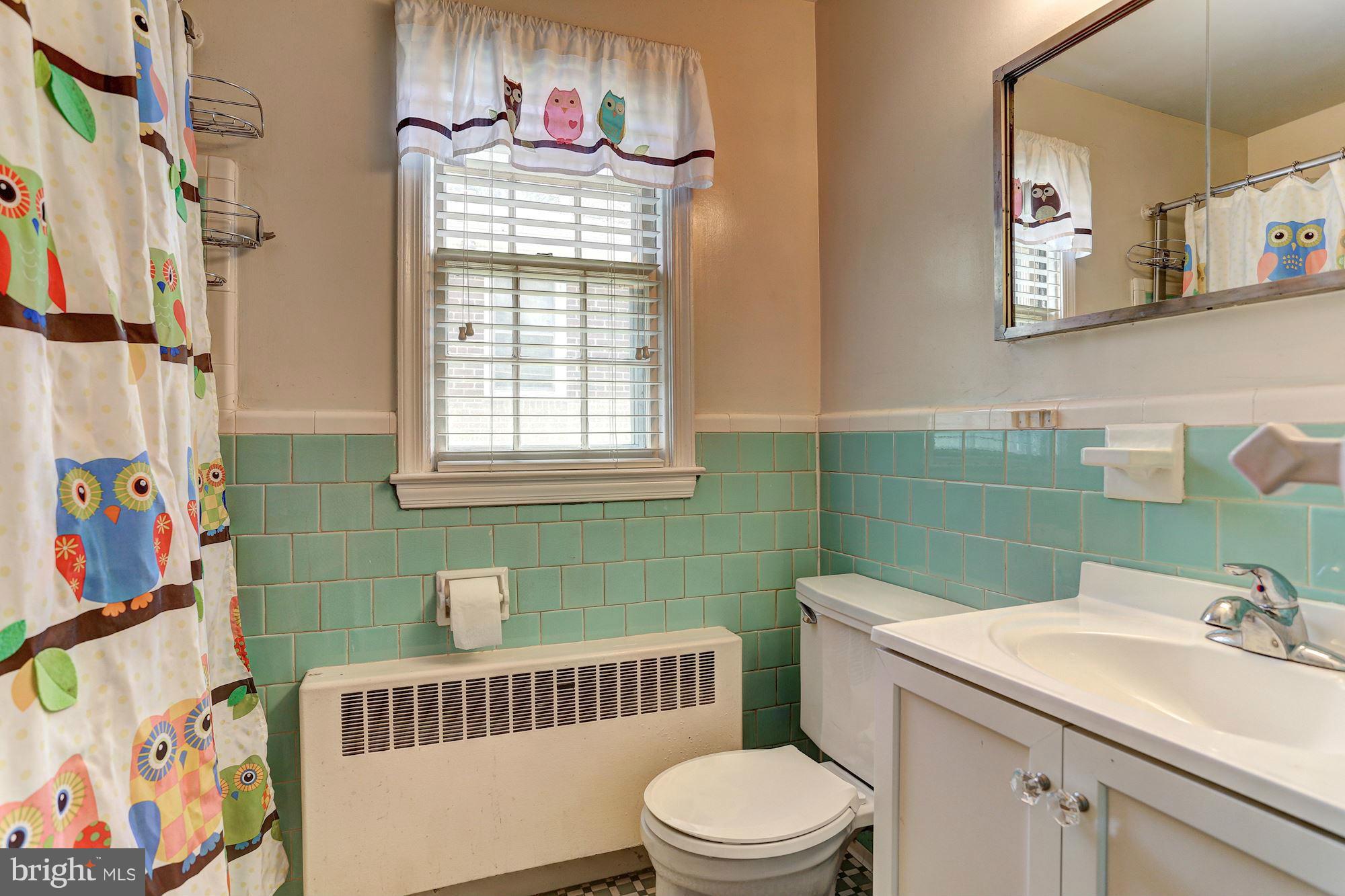 402 North Rolling Road Catonsville, MD 21228 - Photo 10 of 17 a bathroom with a sink a toilet and a shower curtain