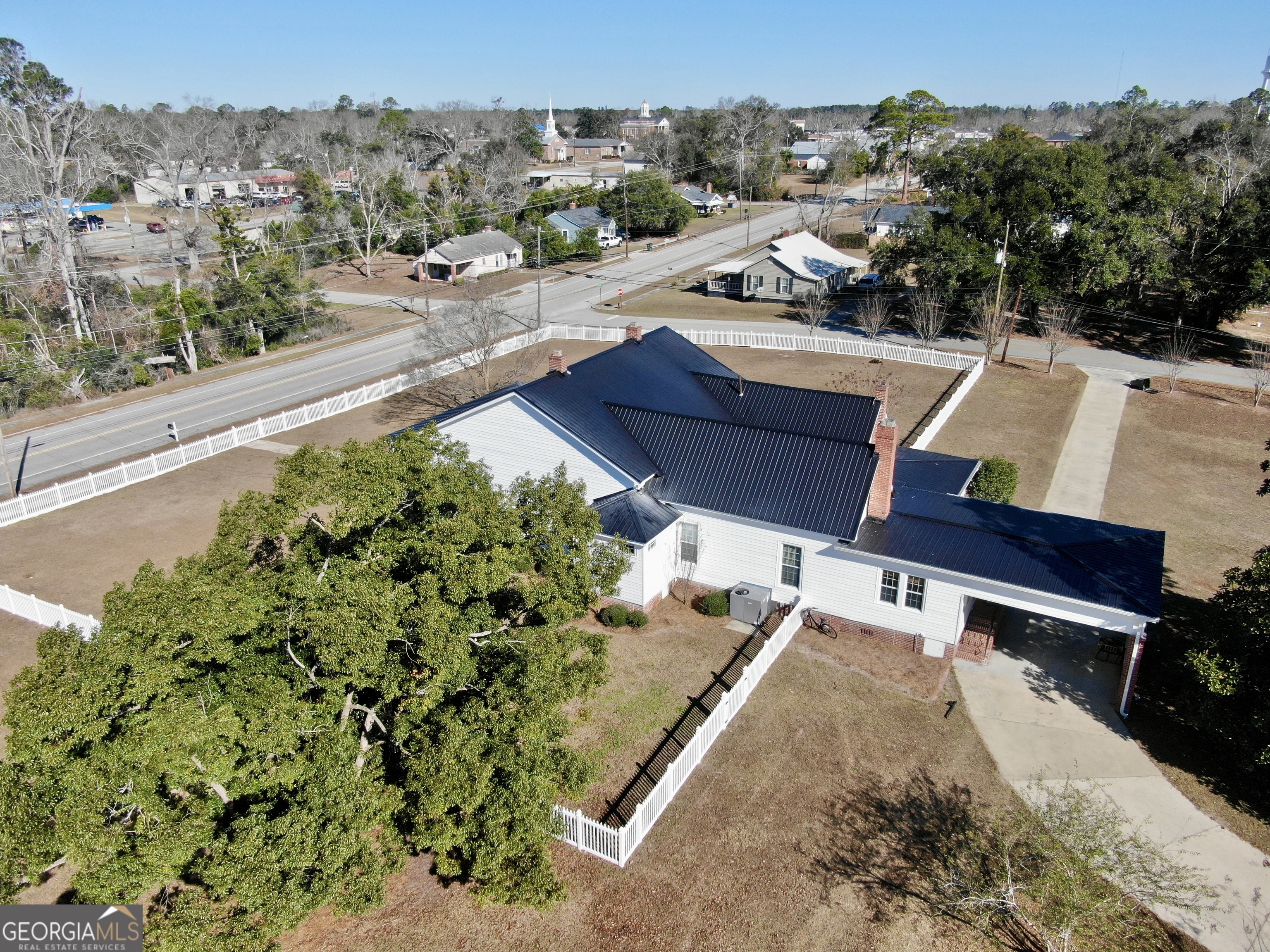 an aerial view of a house with a yard and mountain view in back