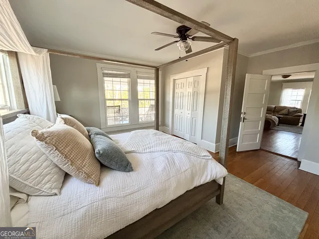 a bedroom with a bed and wooden floor