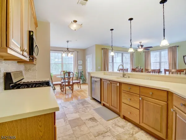 a kitchen with stainless steel appliances granite countertop a refrigerator stove top oven and sink
