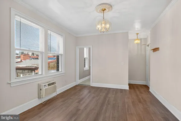 a view of a hallway with wooden floor and a kitchen