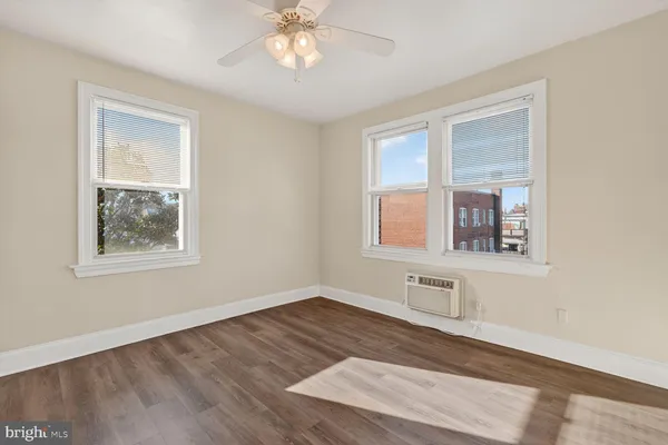 a view of a room with wooden floor and a ceiling fan