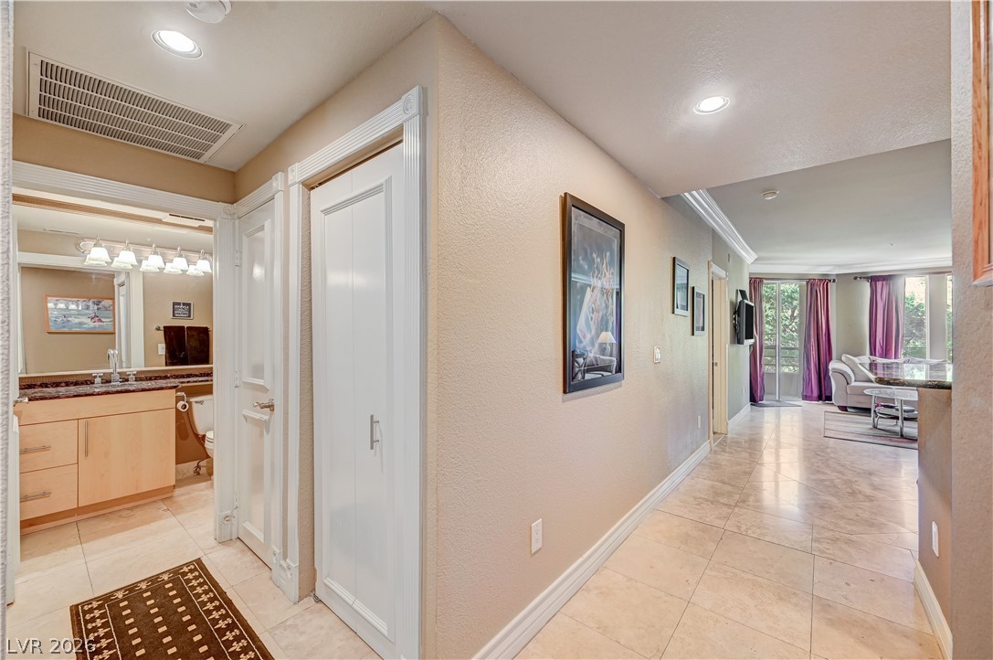 230 East Flamingo Road, Unit 333 Las Vegas, NV 89169 - Photo 8 of 61 Polished tile flooring and recessed lighting line the hallway leading into the living spaces.