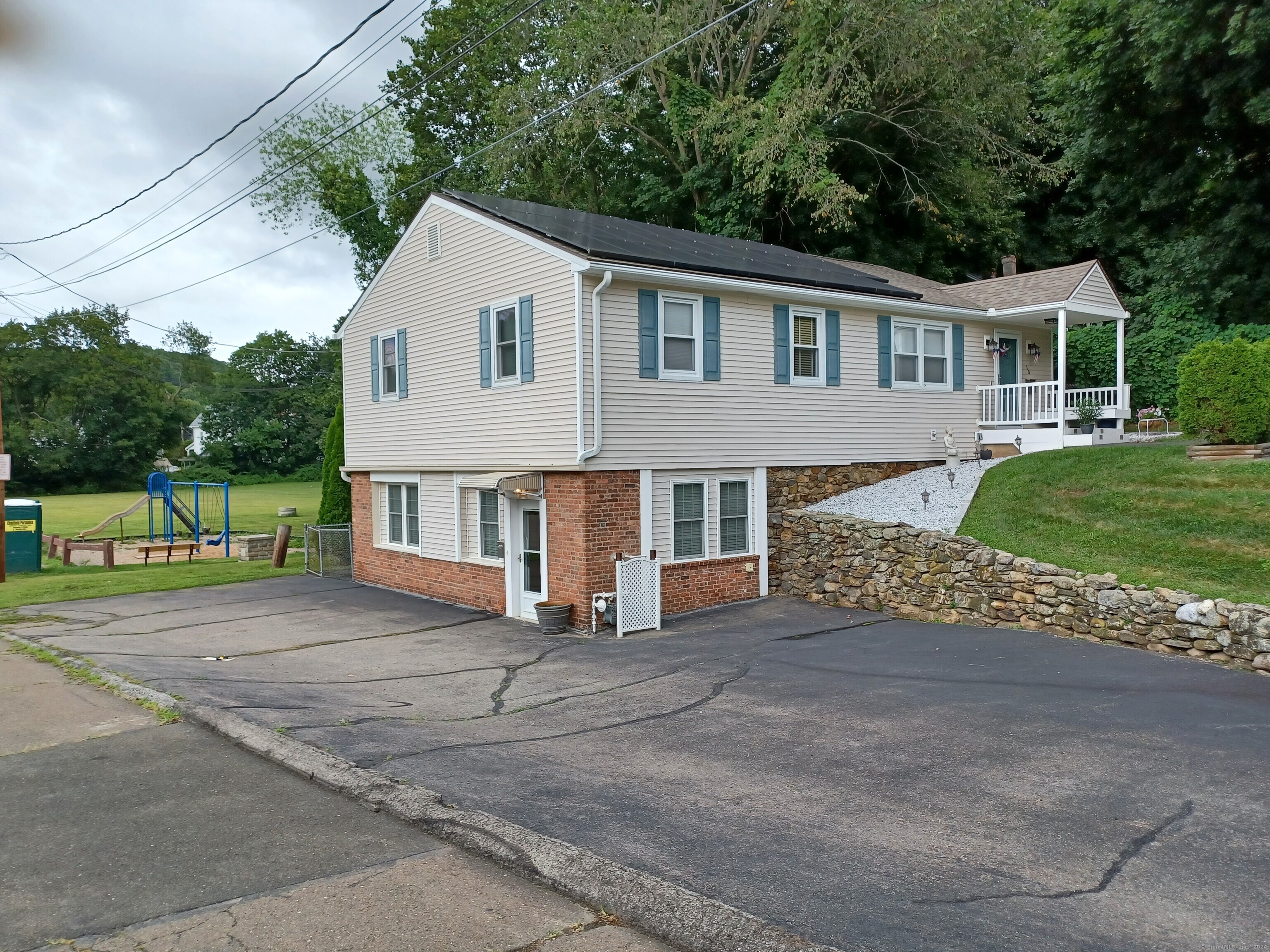 a view of a house with a yard and large tree