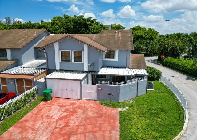 a front view of a house with a garden and trees