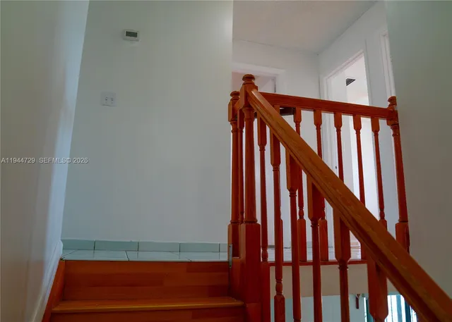 a view of staircase with railing and white walls