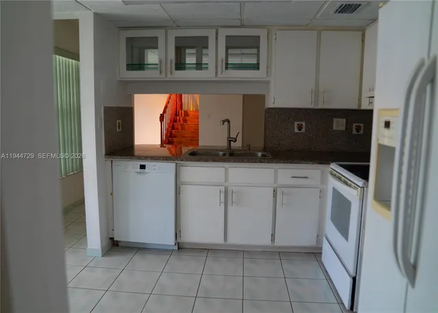a kitchen with white cabinets and white appliances