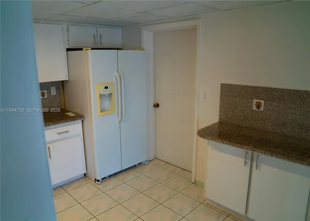 a kitchen with cabinets and refrigerator