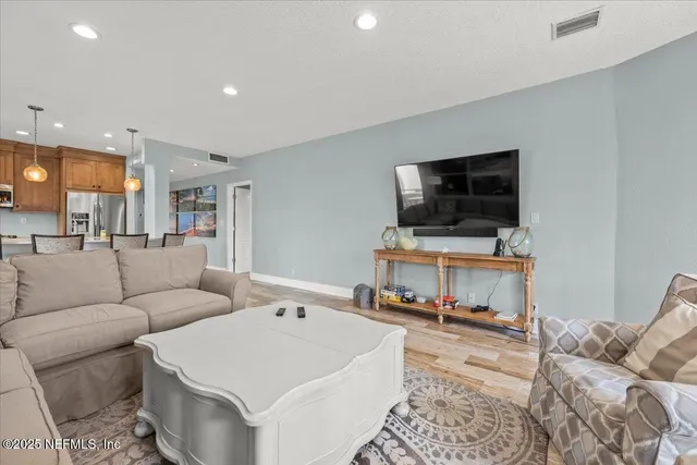 a living room with furniture a rug and a flat screen tv