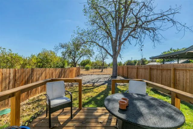 a view of a patio with table and chairs with wooden fence