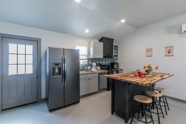a kitchen with stainless steel appliances granite countertop a refrigerator and a stove top oven