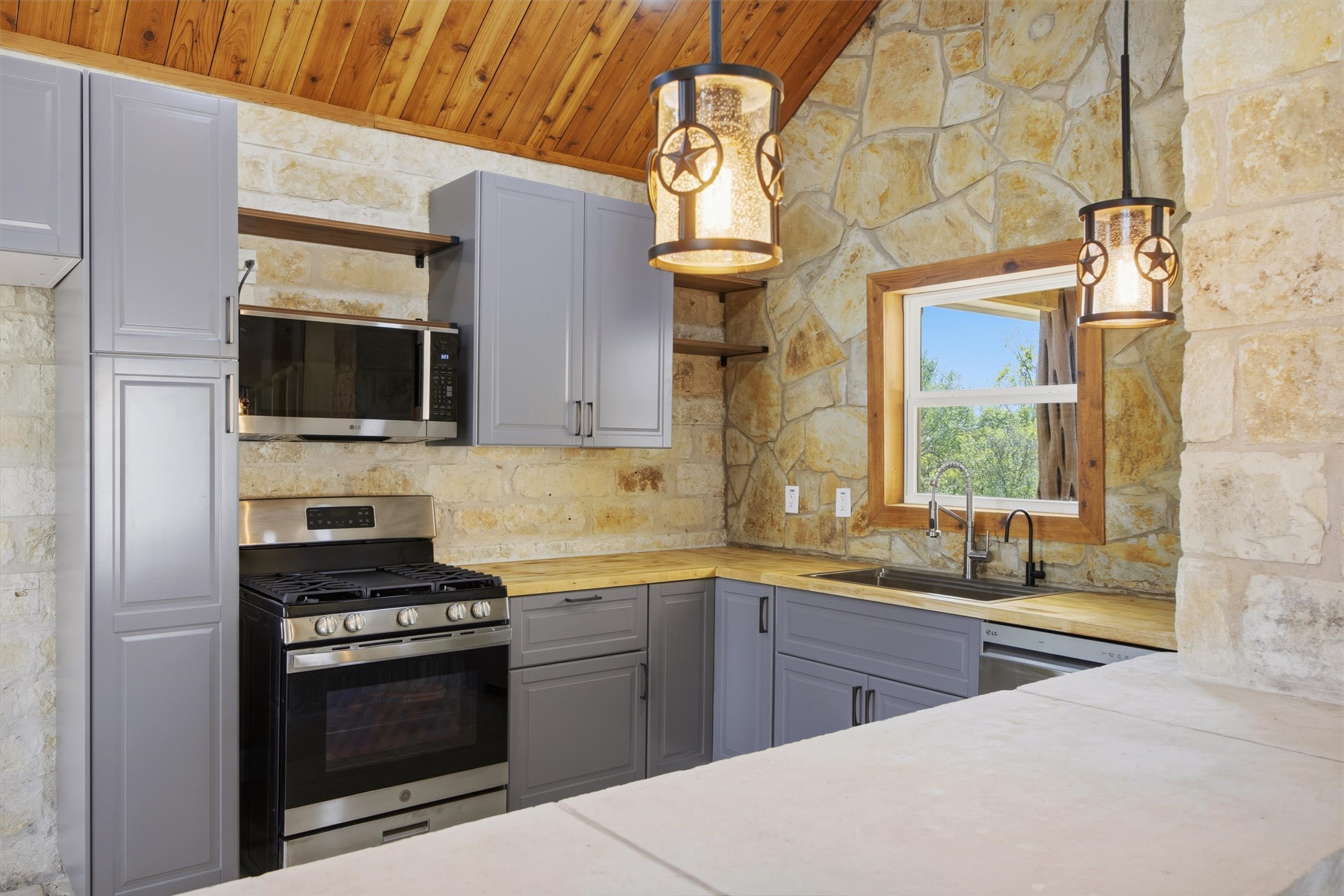 Undisclosed Address Buda, TX 78610 - Photo 4 of 19 a kitchen with stainless steel appliances a stove a sink and a microwave