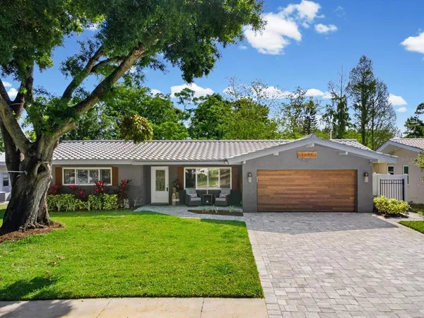 a front view of a house with a garden and trees