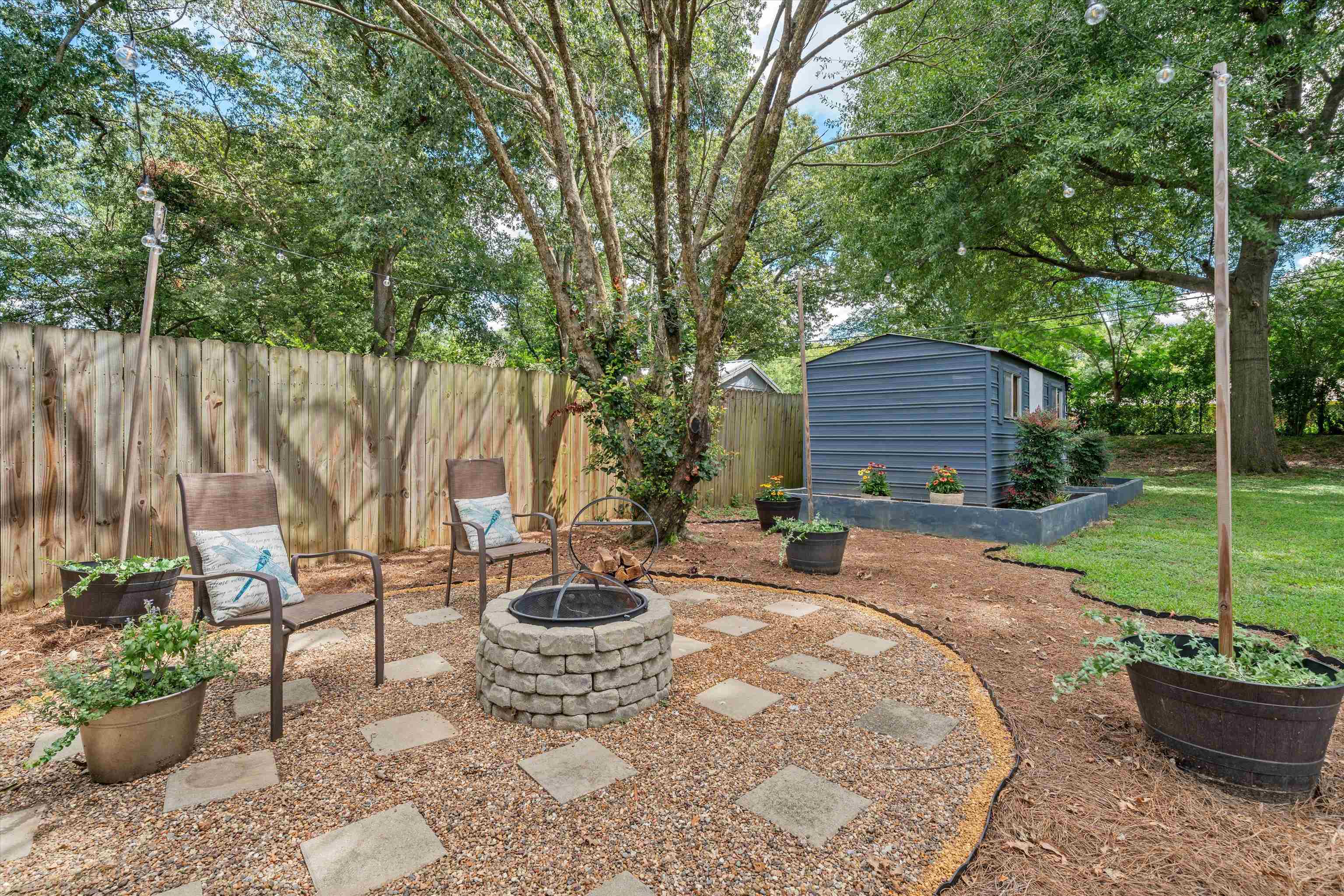 1064 Wilbec Road Memphis, TN 38117 - Photo 19 of 23 a view of a backyard with table and chairs potted plants and a large tree