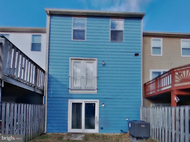 a view of brick house with wooden fence