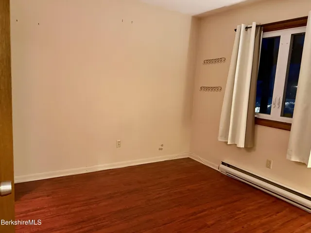 an empty room with wooden floor and a window