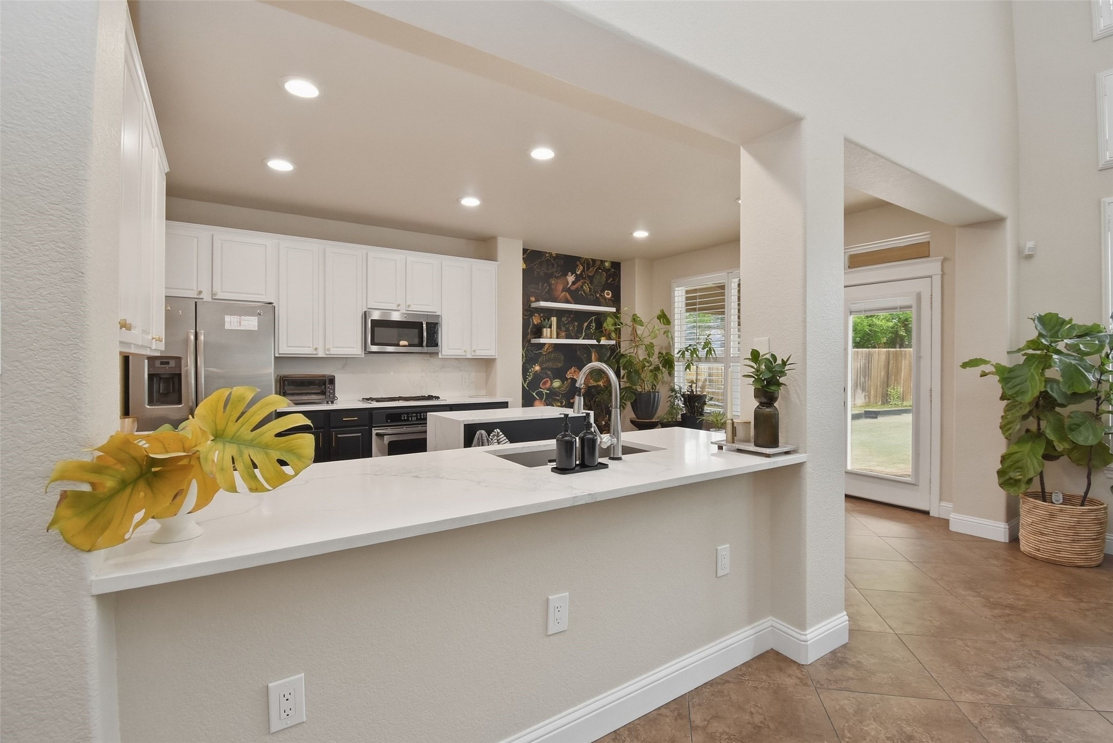 5615 Edgewood Pl Drive Spring, TX 77379 - Photo 18 of 48 Modern kitchen with a large breakfast bar, sleek countertops and stainless steel appliances, offering both style and functionality.