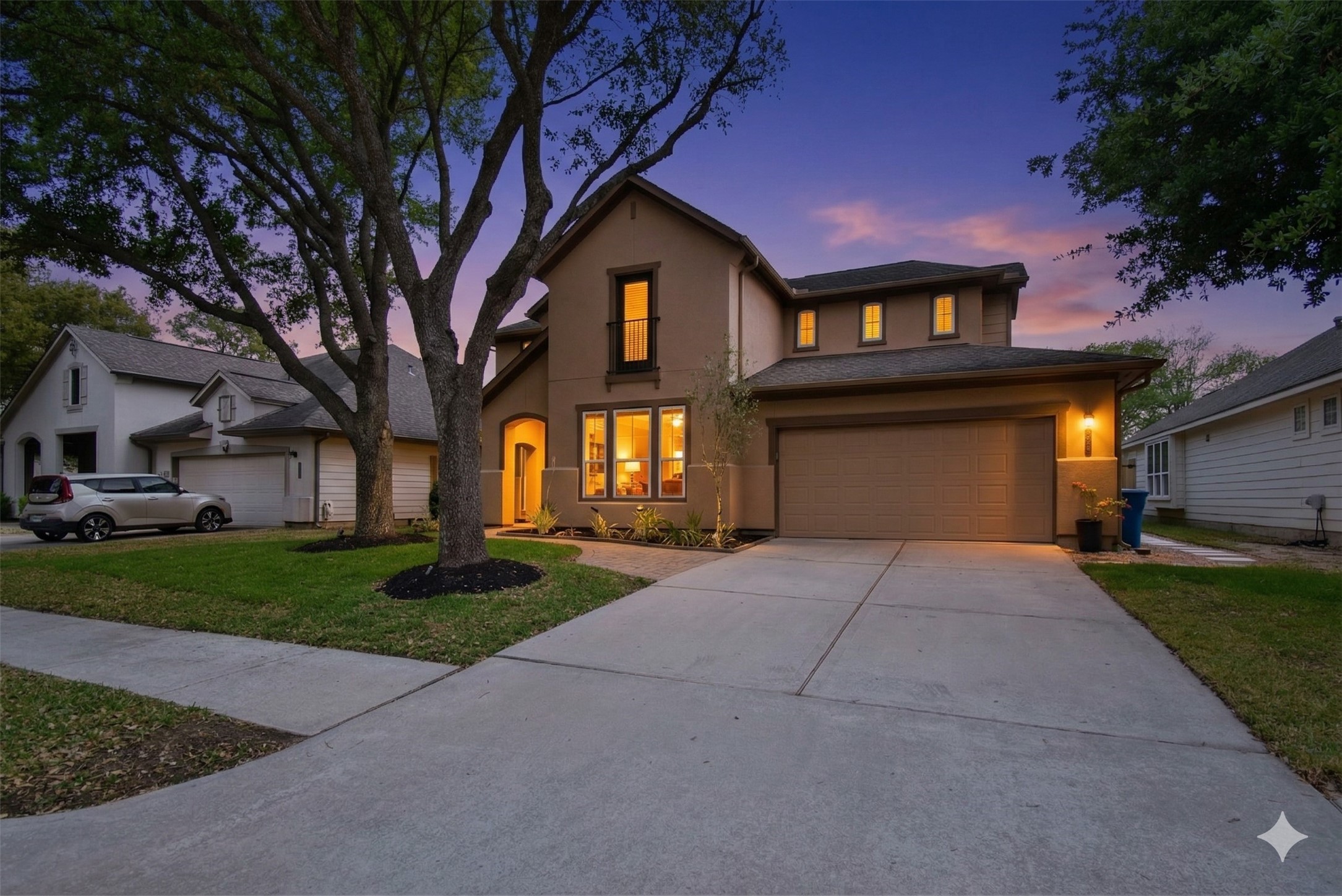 5615 Edgewood Pl Drive Spring, TX 77379 - Photo 2 of 48 Striking two-story exterior with a wide driveway, mature trees and a two-car garage, highlighted by warm lighting that enhances the home’s inviting curb appeal at dusk.