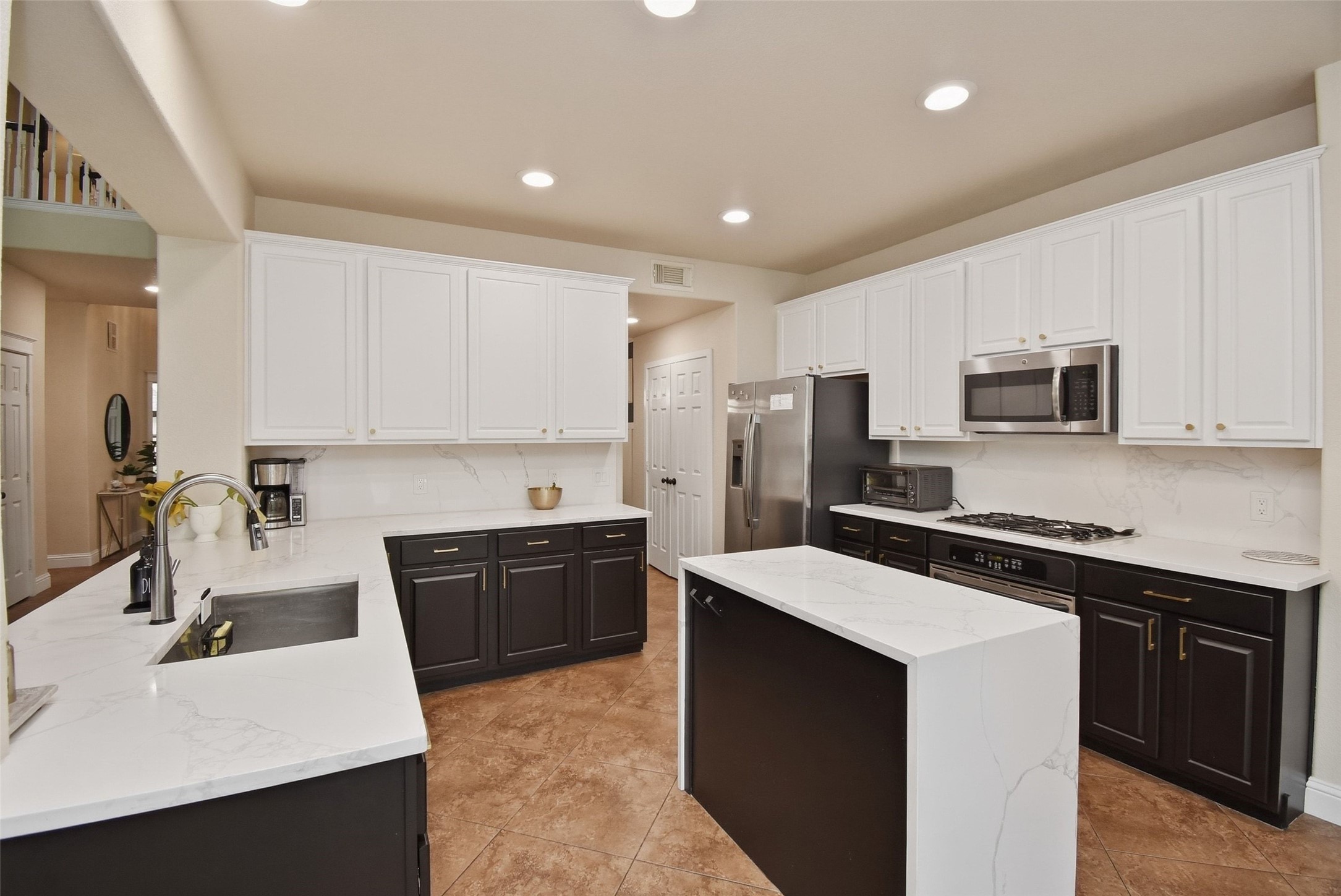 5615 Edgewood Pl Drive Spring, TX 77379 - Photo 21 of 48 Updated kitchen featuring a large center island, quartz countertops, stainless steel appliances and ample cabinetry, designed for both everyday living and entertaining.