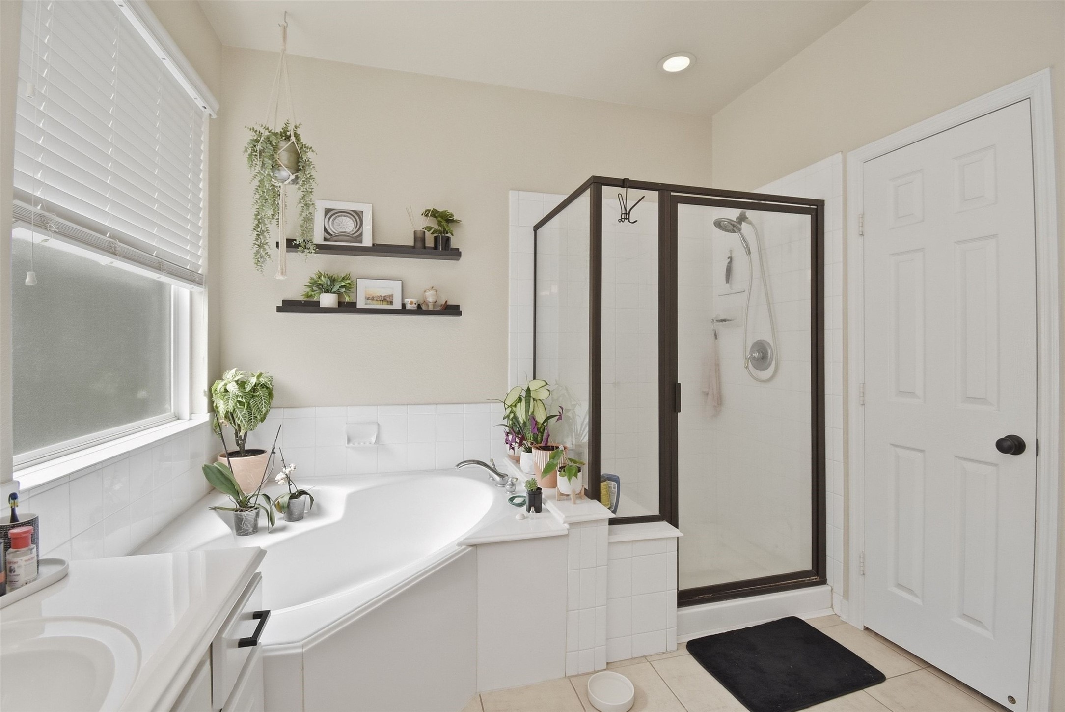 5615 Edgewood Pl Drive Spring, TX 77379 - Photo 31 of 48 Primary bathroom featuring a soaking tub and separate glass-enclosed shower, complemented by natural light and clean, modern finishes.