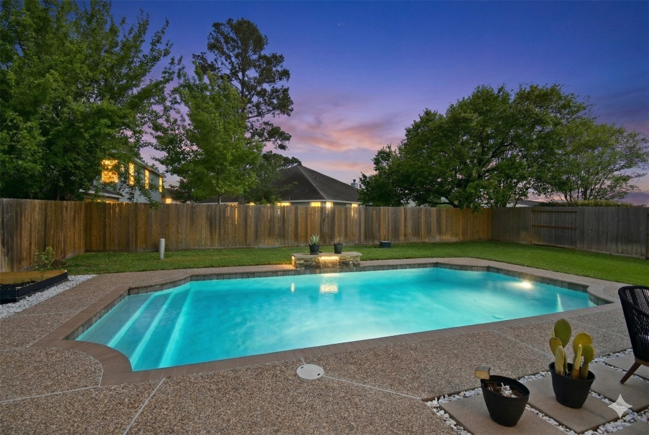 5615 Edgewood Pl Drive Spring, TX 77379 - Photo 45 of 48 Sparkling pool with elegant water feature, beautifully illuminated at dusk for a true resort-style experience.
