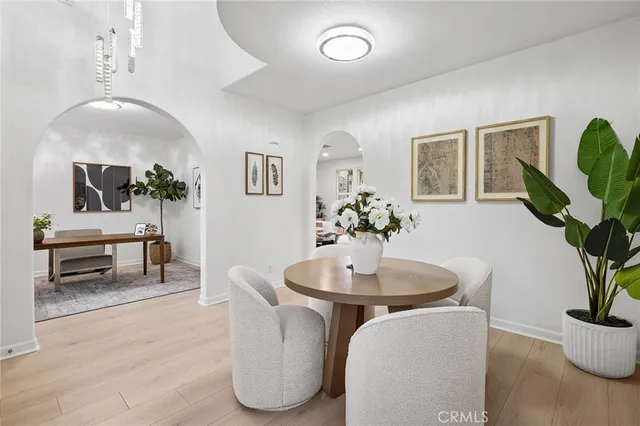 a living room with furniture a potted plant and a wooden floor