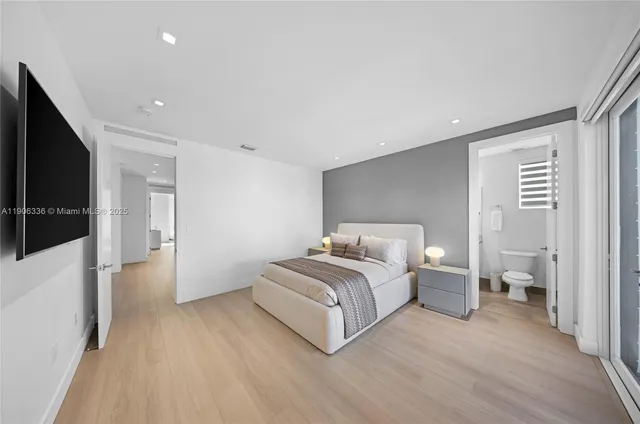 a spacious bedroom with a bed and a flat screen tv