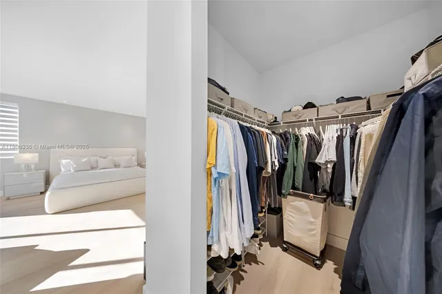 a view of walk in closet with clothes and shoes