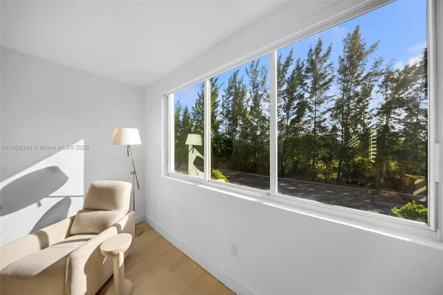 a view of a room with a large window and chairs