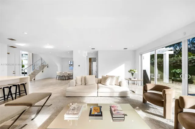 a living room with furniture and large windows