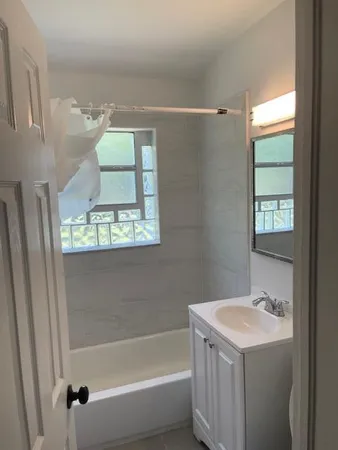 a bathroom with a tub sink and mirror